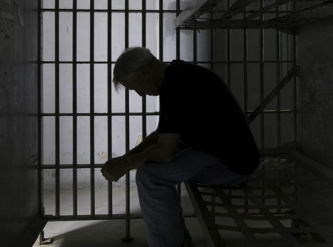 Man-sitting-prison-480x357